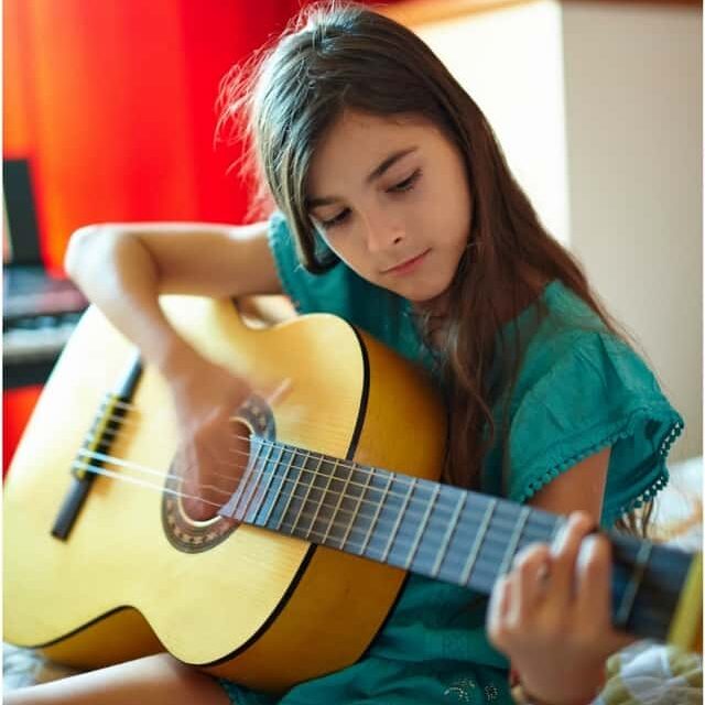 Girl learning guitar at Maestro Musicians Academy